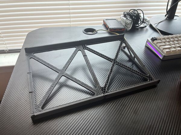 The fused four-piece PPA-CF frame lying flat, showing its triangulated truss top and honeycomb infill at the seams.
