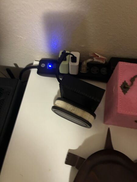 The assembled purifier with its filter fitted, powered by USB on a desk.