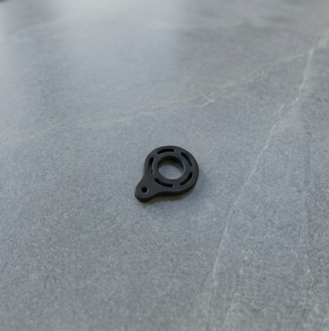 Cloudial 3D-printed carbon fiber keychain spinner on a stone surface